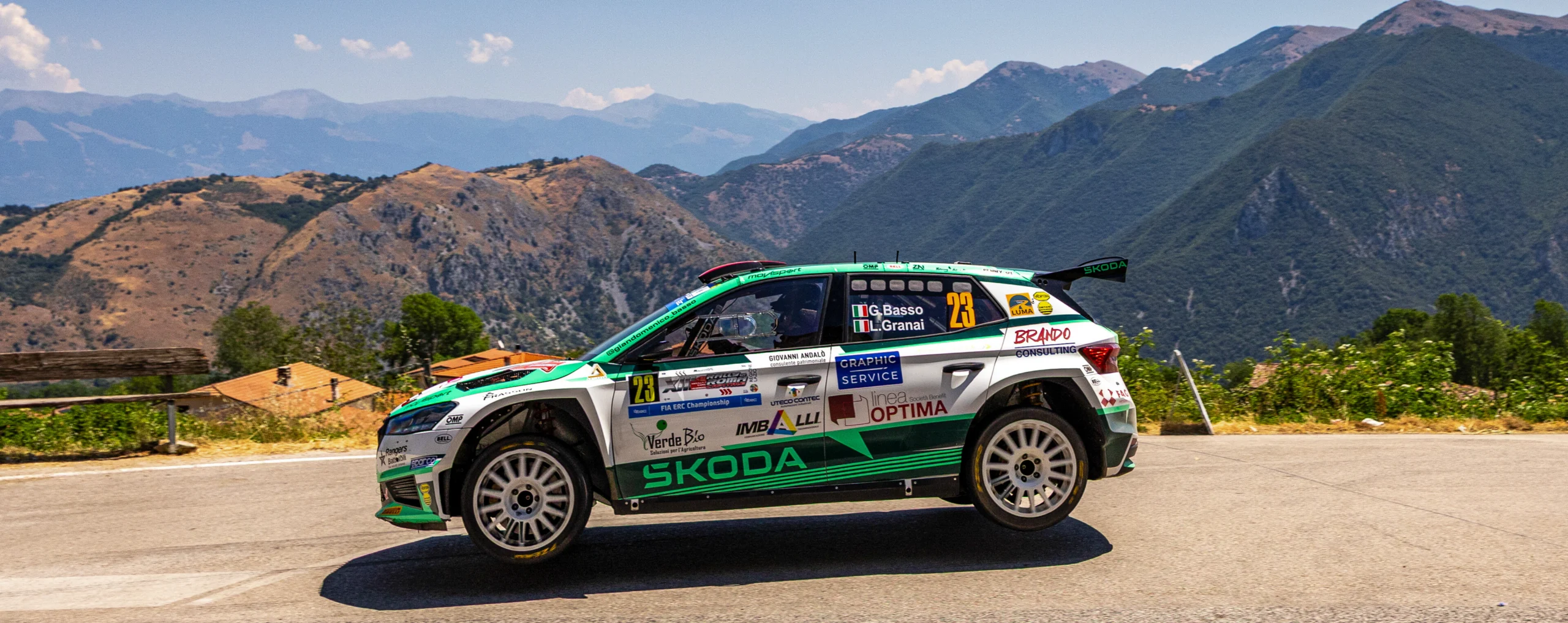 Auto da rally in prova speciale tra le colline mentre salta durante la prova