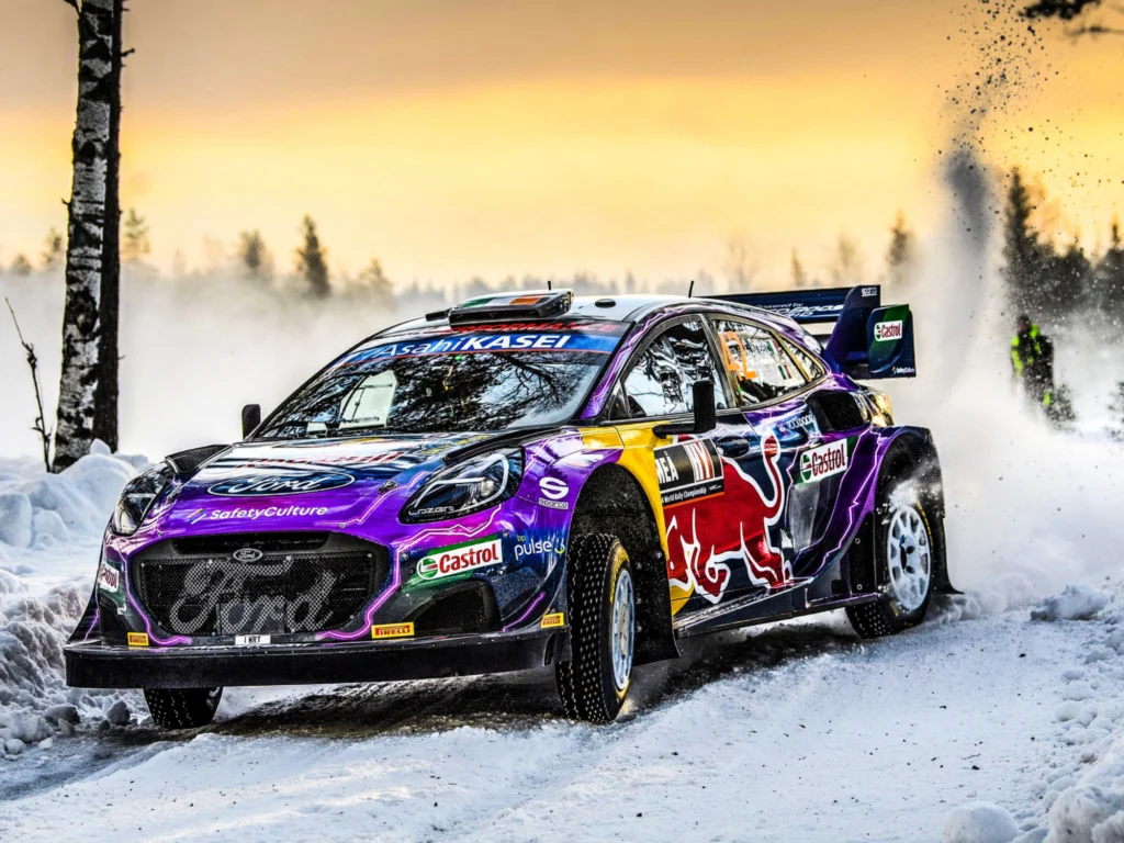 Auto WRC che affronta una curva su terreno ghiacciato in un paesaggio innevato durante lo special stage di una gara rally
